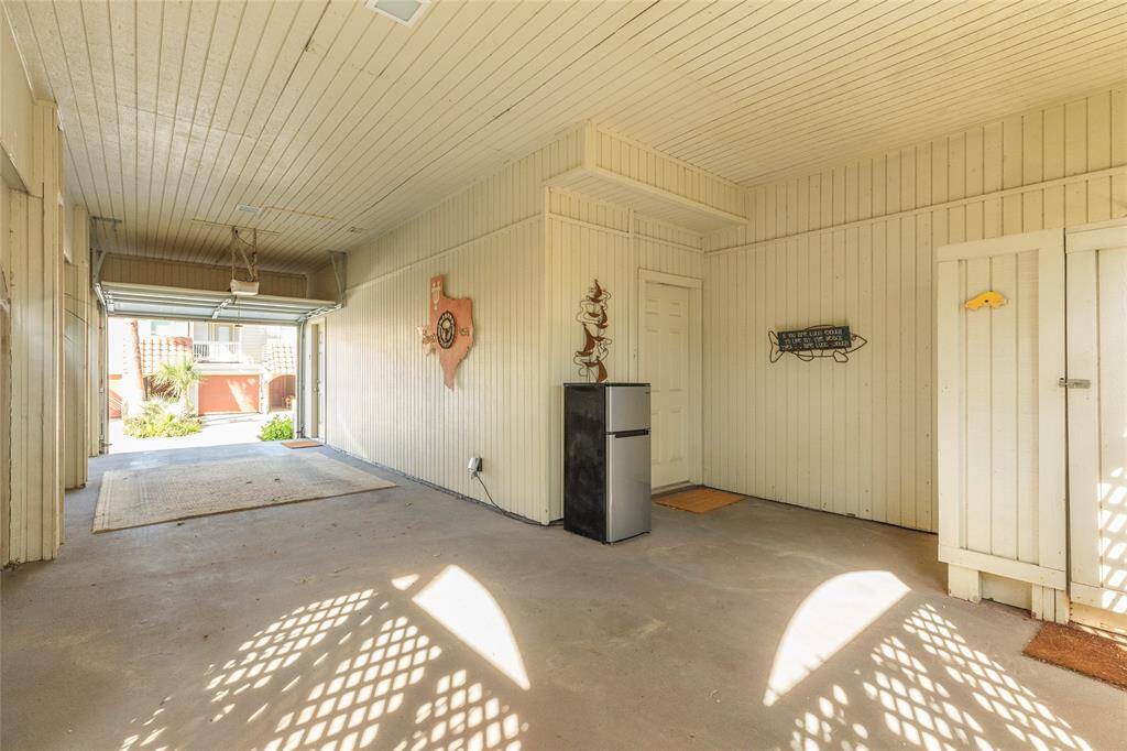 The garage offers an electric opener on the tandem parking spaces and is home to a private, outdoor shower (right) and the door beside the garage fridge is a HUGE walk-in, storage closet.