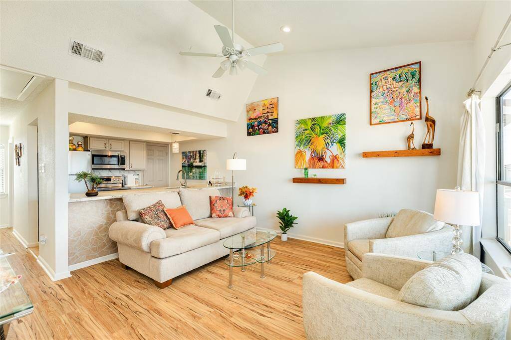 Looking back toward the kitchen, notice this owner uses the entire space for seating but this flexible area is large enough for 6 barstools at the huge kitchen bar. You can easily put the sofa back on the wall below the art.