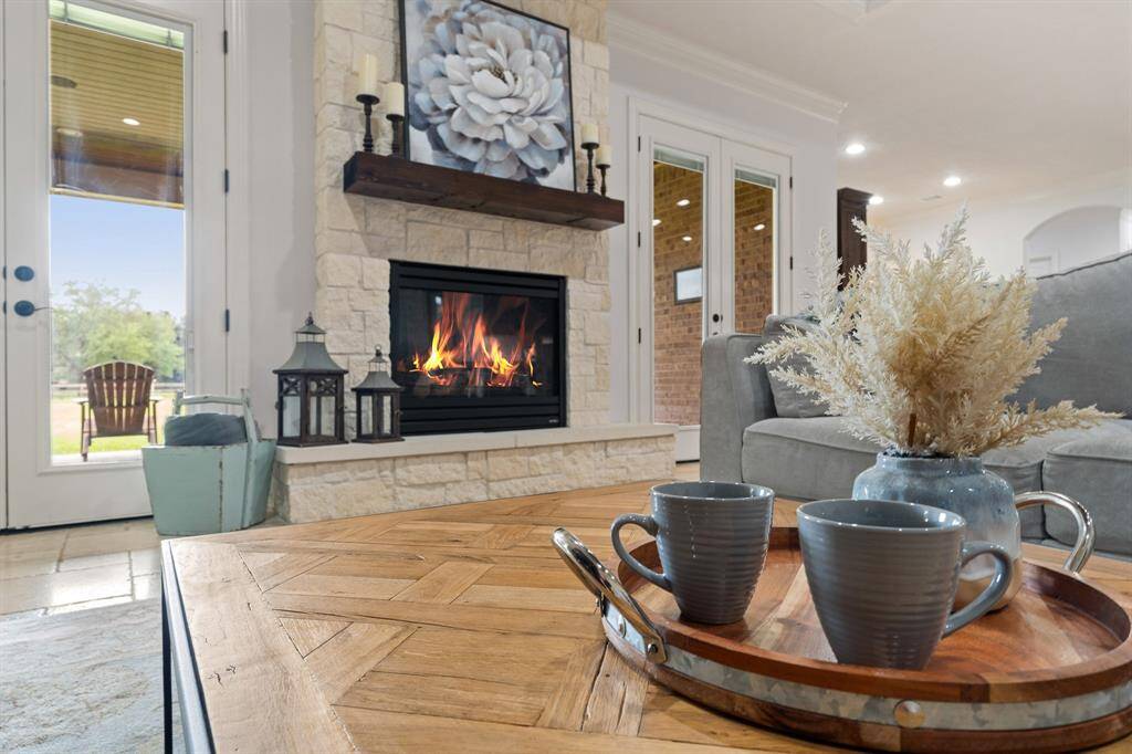 Cozy up on a chilly day by this gas fireplace, with floor to ceiling stone surround and oversized hearth.  The custom wood mantle adds contrast to the fireplace, while also tying in nicely to the wood planked ceiling above.
