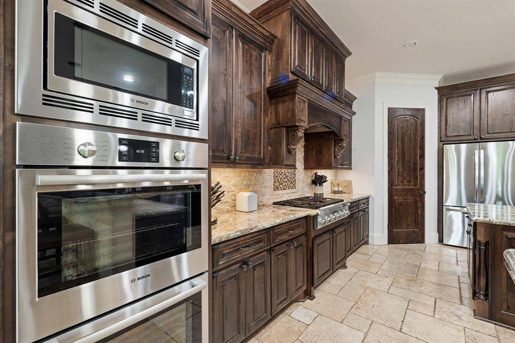 The Kitchen comes equipped with Bosch dual ovens, a built-in Bosch microwave, whisper quiet dishwasher, and Thermador  6-burner gas range. The door straight ahead leads to the spacious, walk-in pantry with built-in shelving.