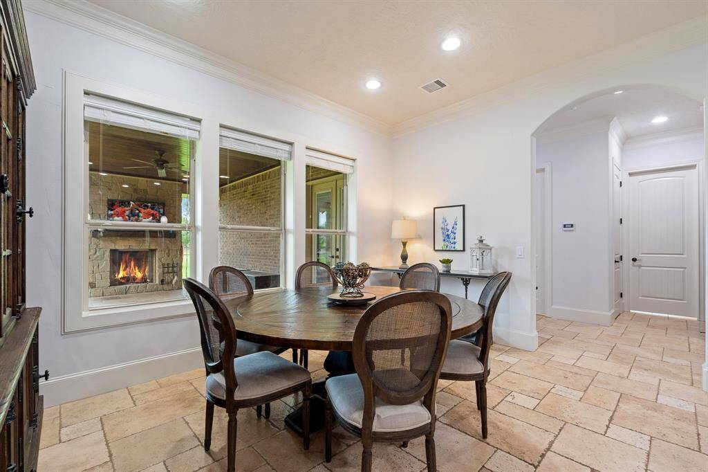 The Breakfast Room, located directly off the Kitchen, is illuminated by a trio of cased windows overlooking the Back Patio. There is plenty of space to accommodate just about any size table, as well as additional furniture like a buffet or drink cart. The archway straight ahead leads to the Powder Room, Laundry Room, and Game Room.