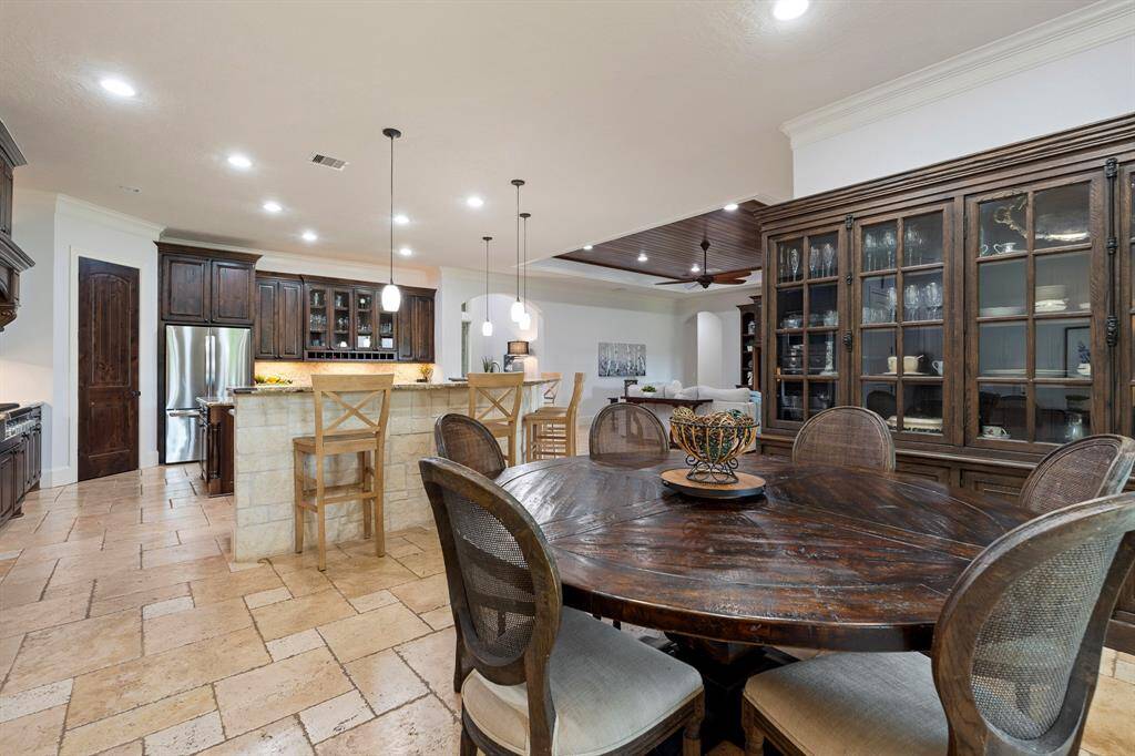 This desirable open concept design keeps sightlines open and makes entertaining effortless. Crown molding, warm wood paneling, arched openings, and Travertine flooring add to the high-end feel of the home.