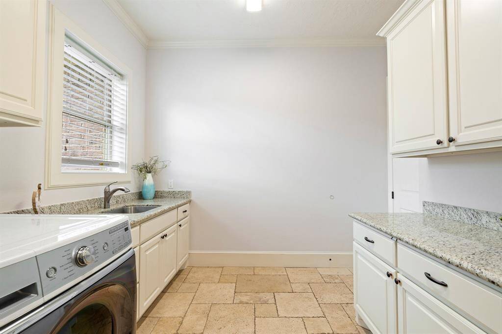Another view of the Laundry Room shows additional storage space, making it easy to store all your cleaning products, stain fighters, and extra linens. Folding and sorting is made easier thanks to this large counter space separate from the sink.
