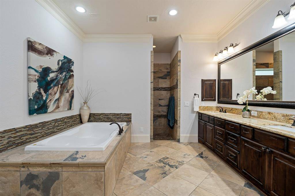 Relax and unwind in this spacious Primary Spa. The earthy tile flooring continues into the glass-free shower that includes dual shower heads, dual storage cubbies, a privacy window, and a large bench.