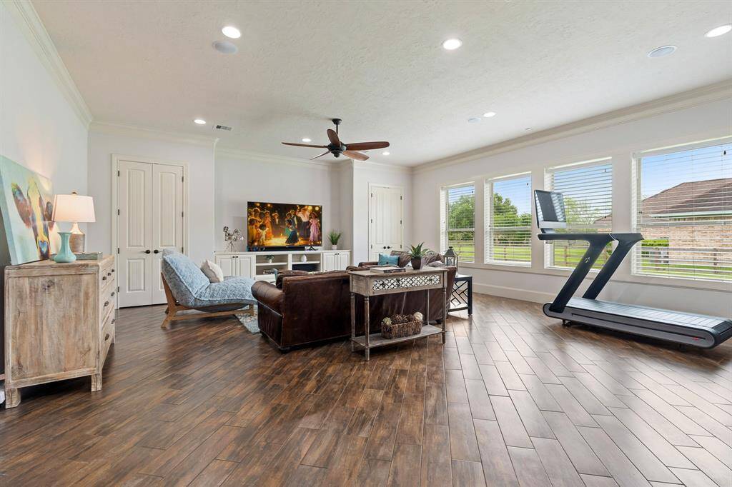 Tucked away in its own wing of the home sits this spacious Game Room. Wood-like tile flooring makes floor clean up a breeze while crown molding, extra-wide baseboards, and recessed lighting really dress up the space. Two closets help keep the room tidy by providing a home for games, toys, and accessories.