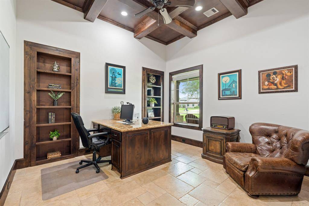 The beautiful Travertine  flooring continues into the Study and is anchored by the tastefully, formal, stained baseboards and coffered ceiling. A front-facing window directly overlooks the Front Porch and expansive Front Yard just beyond. The pair of built-in wood bookcases provide ample space to showcase your favorite books, pictures, and family mementos.