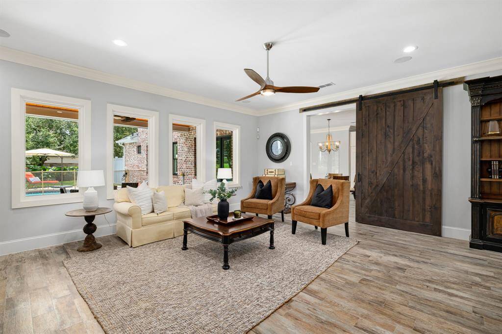 Solid wood rail barn door from Detering accents the family room and gives privacy to the kitchen if desired.
