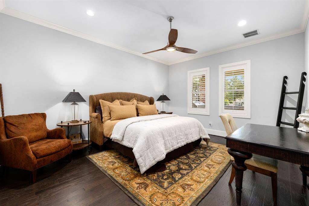 This spacious primary bedroom is one of four primary suites and is quite the retreat with hardwood flooring, recessed lighting, modern ceiling fan, and plantation shutters overlooking the back of the property.