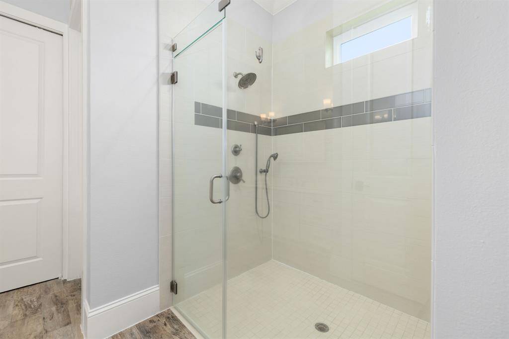 Oversized shower with additional handheld sprayer and attractive tile. Shower window brings in natural light.