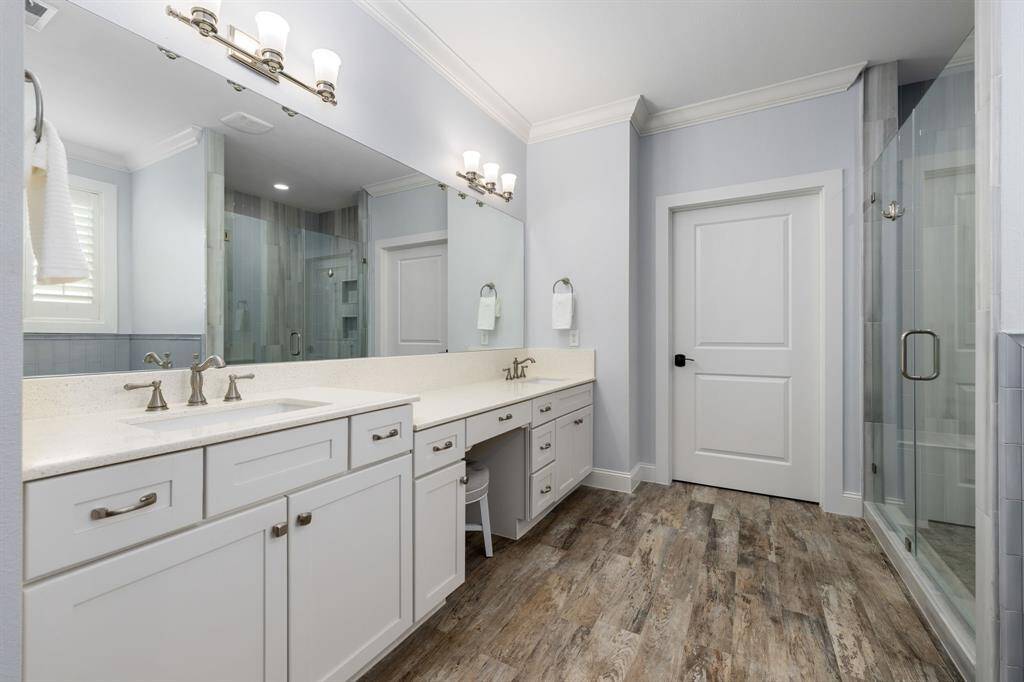 This primary bathroom is truly a haven for relaxation featuring dual vanities and an oversized shower and freestanding tub. You will love relaxing in the spacious shower with a mixture of classic tile selections and stylish hardware.