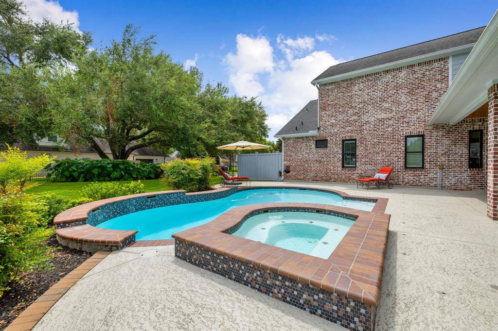 Surrounded by lush landscaping, the expansive sparkling pool, complete with a spa, creates a picturesque setting. Its inviting waters promise endless hours of enjoyment, offering a perfect oasis for relaxation and fun in the comfort of your own backyard.