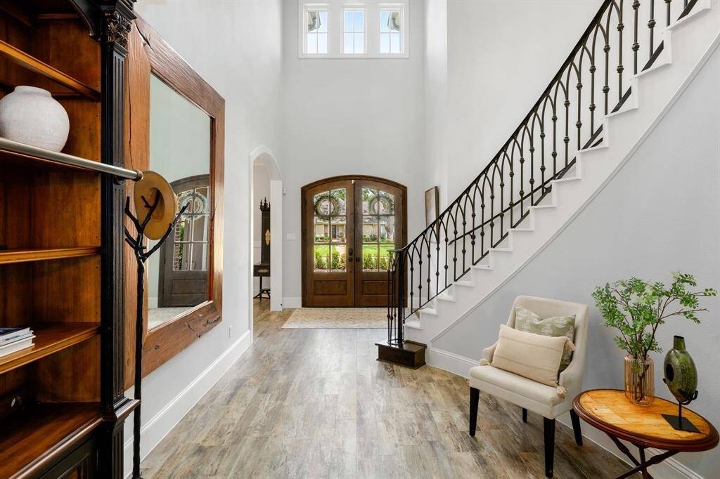 Wow, step inside and you will be captivated by the two story ceilings, incredible natural light, and the curated feel of the thoughtfully sourced finishes that provide a mix of textures, pops of color, and the most amazing hand forged sweeping iron steel stair rail.
