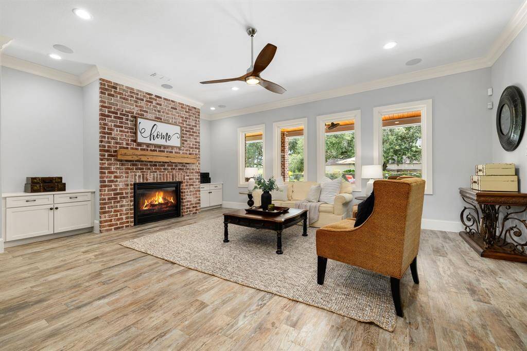 Comfortable living room with views of the patio, pool and golf course. Features include crown molding, gas log fireplace with solid wood mantle, built-in cabinetry, and built-in surround sound speakers.
