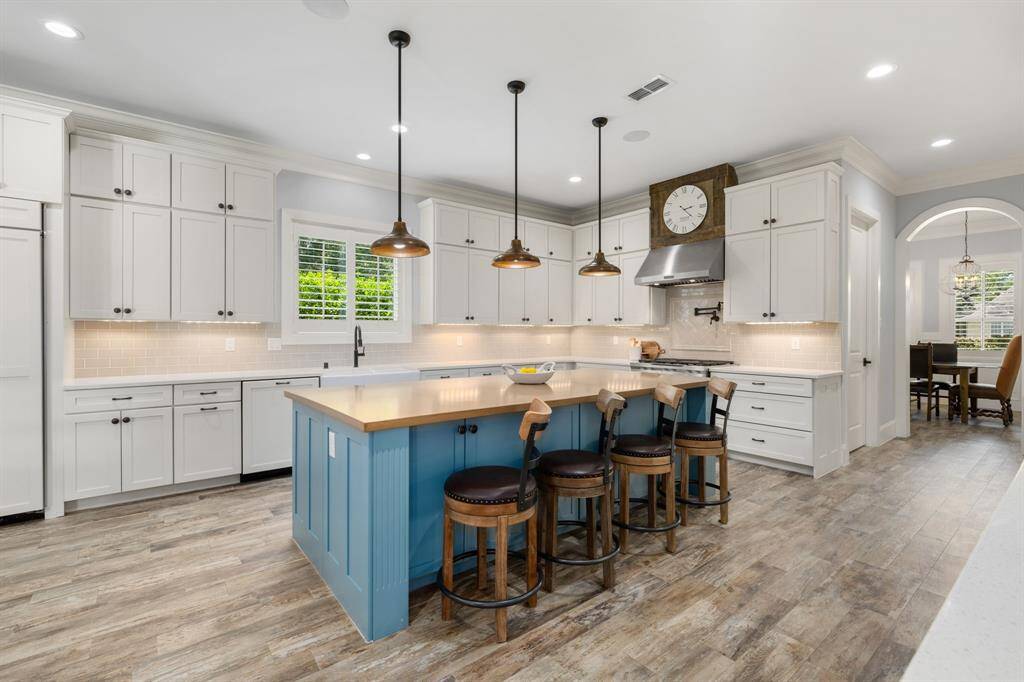 The kitchen features custom built soft close shaker cabinets and drawers with attractive hardware, quartz countertops, an apron front porcelain farmhouse sink and a large island with storage and seating. Can you imagine cooking and entertaining here? What a dream!