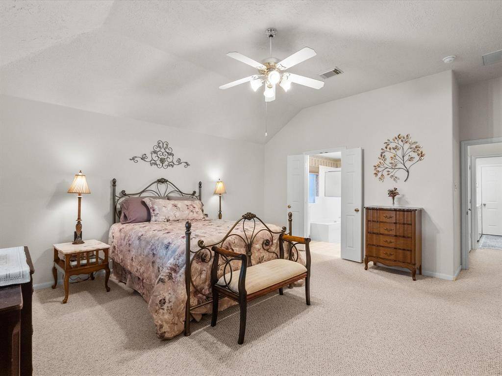 The large primary suite is part of a split floor plan and sits just off the kitchen, offering a spacious and private retreat from the main living areas.