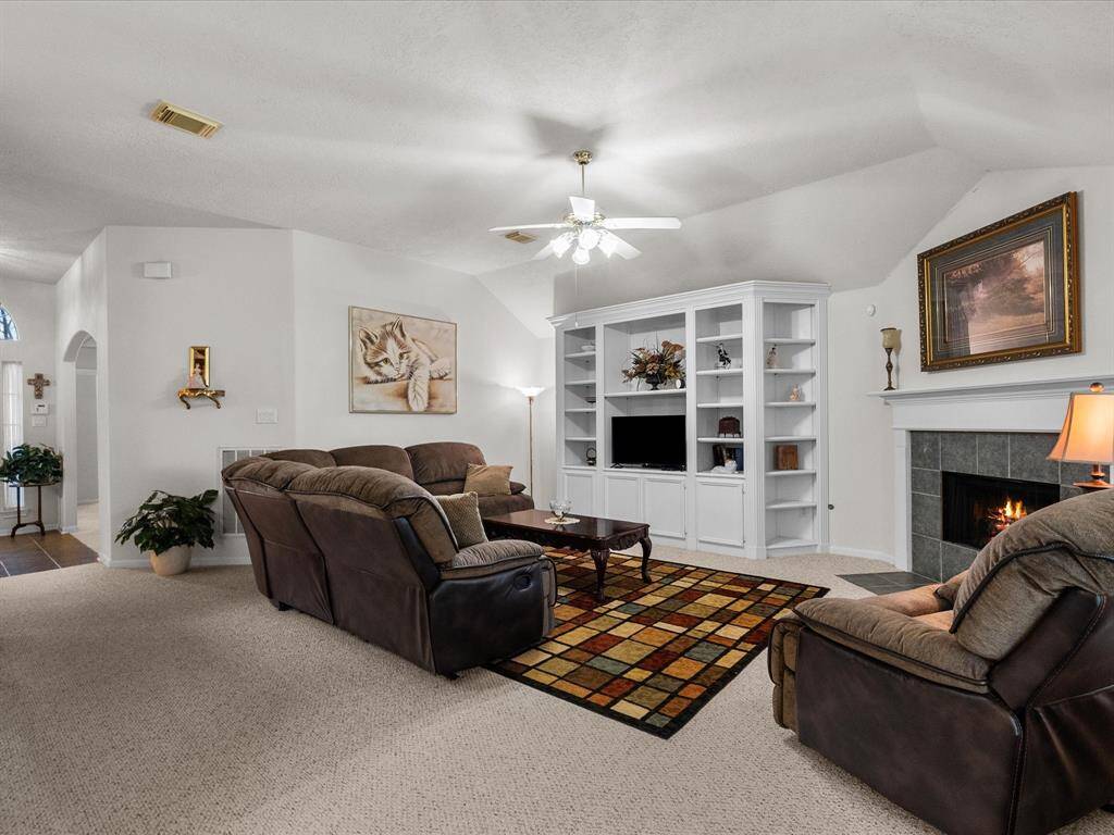 The spacious family room features built-in cabinets and a cozy gas fireplace, with a seamless flow into the open kitchen—perfect for everyday living and entertaining.