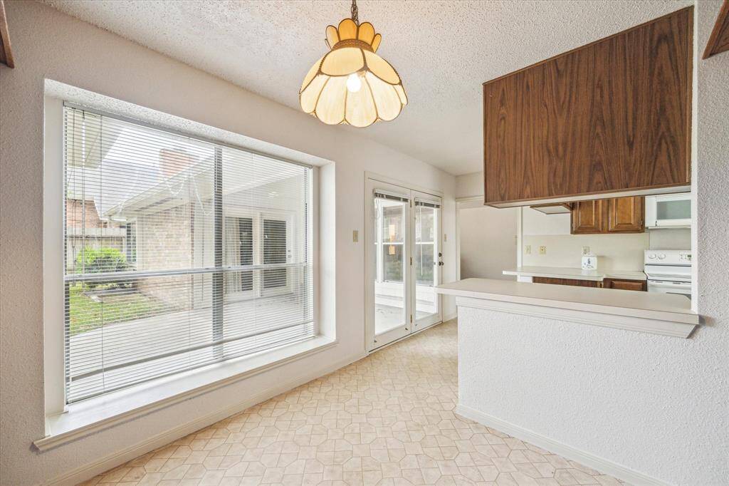 Kitchen offers access to the covered patio and backyard along with a pretty green view!
