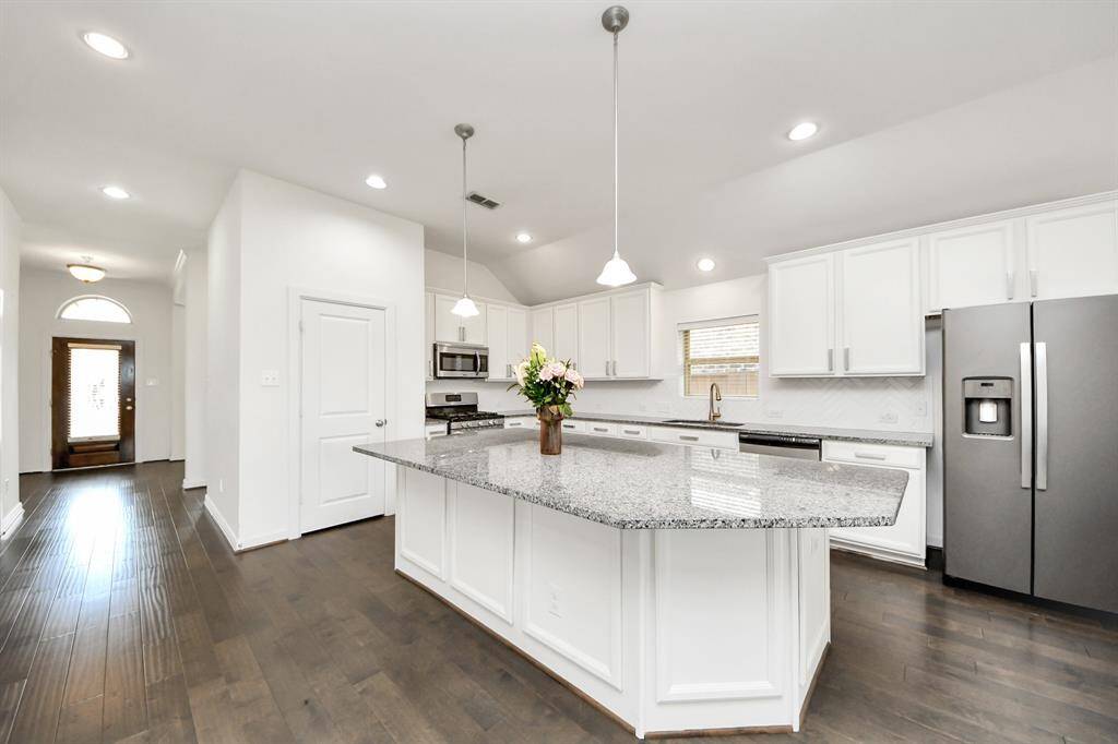 The heart of the home is the stylish and functional kitchen, featuring sleek stainless steel appliances that blend seamlessly with modern cabinetry and finishes.