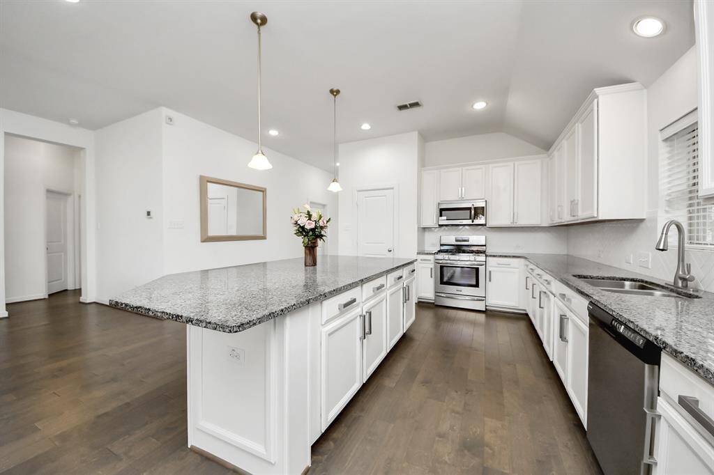 The kitchen flows effortlessly into the expansive living room, creating an open and airy layout that encourages connection and conversation.