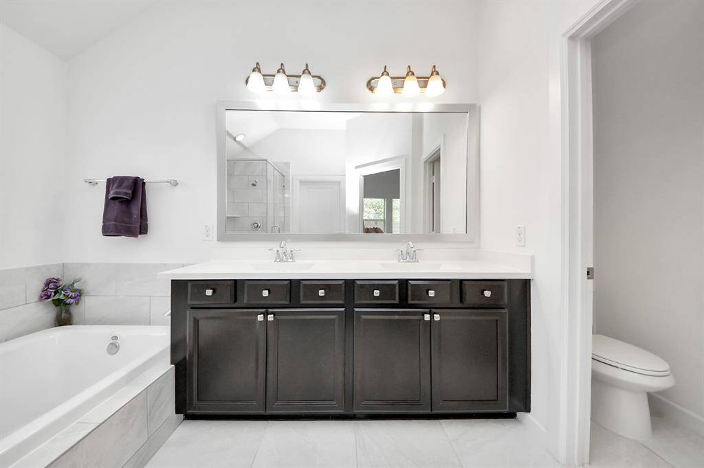 Dual vanities provide ample space for morning routines, while a private water closet adds convenience.