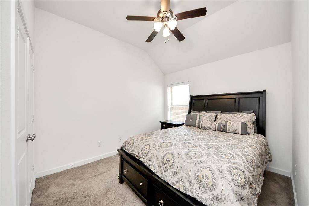 Cozy and inviting secondary bedroom with natural light and a vaulted ceiling, perfect for relaxation.