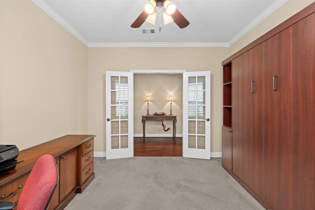 This private study area features elegant French doors and plush carpeting that absorbs sound, creating the perfect environment for reading, enjoying a hobby, or working from home in peace.