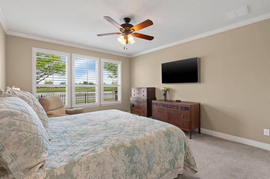 Just look at this peaceful retreat—what a view! The owner’s suite is tucked privately at the back of the home, with beautiful plantation shutters adding a touch of elegance and charm.