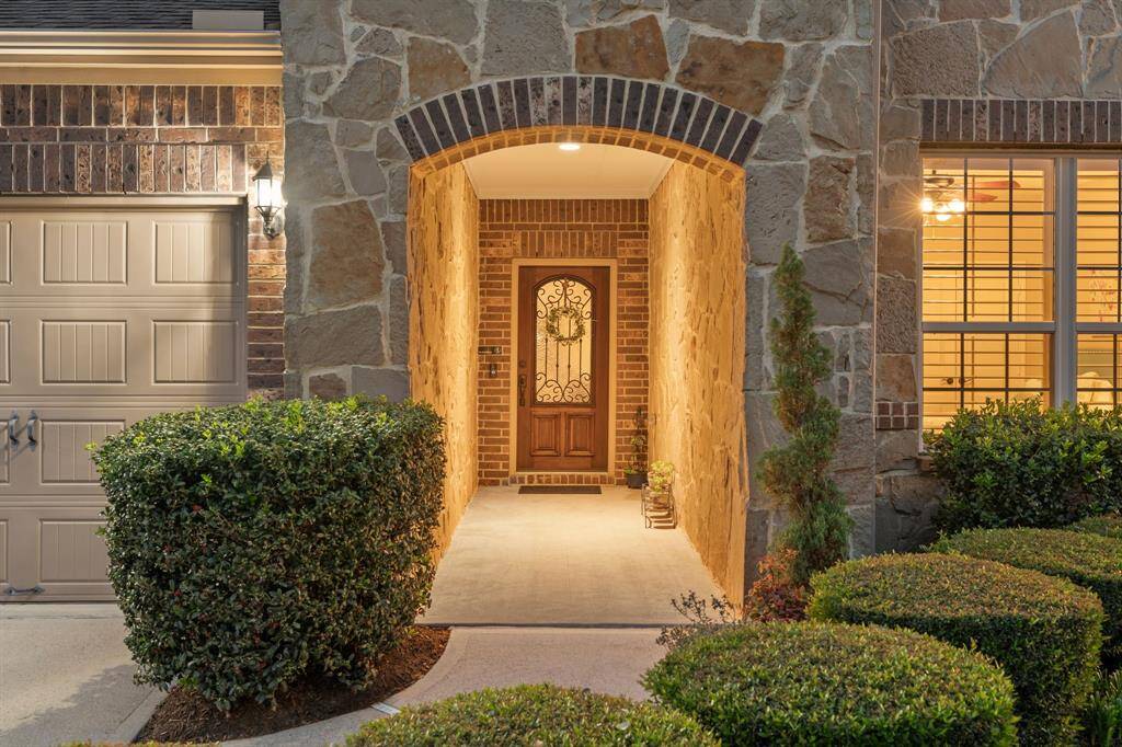 The front porch invites you in with its warm glow and elegant archway—offering a glimpse of the comfort and style waiting inside.