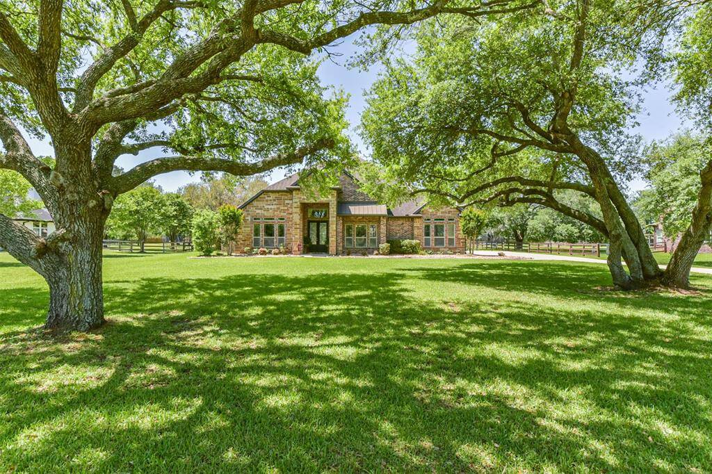 This charming home features a beautiful brick exterior surrounded by lush greenery and mature trees, offering a serene and spacious front lawn. Perfect for those seeking tranquility and natural beauty.