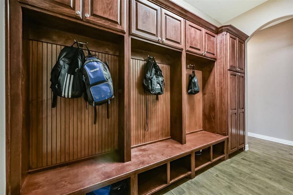This photo showcases a spacious mudroom with elegant wooden cabinetry and storage cubbies, providing ample space for organizing coats and bags. Ideal for keeping your entryway tidy and functional.