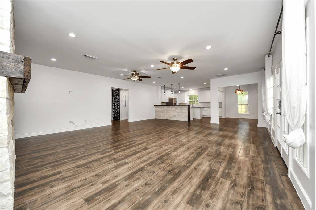 Large open living room with tons of natural light and entry to back yard. It is open to the kitchen area for that open feel.