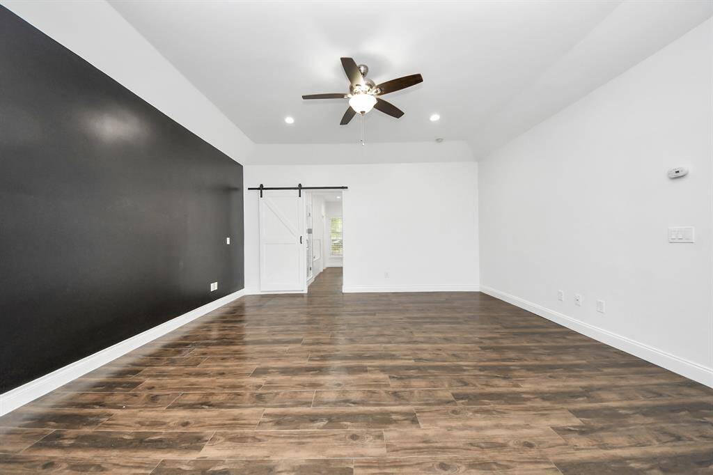 This primary bedroom is massive, with recessed lighting, as seen throughout the downstairs.