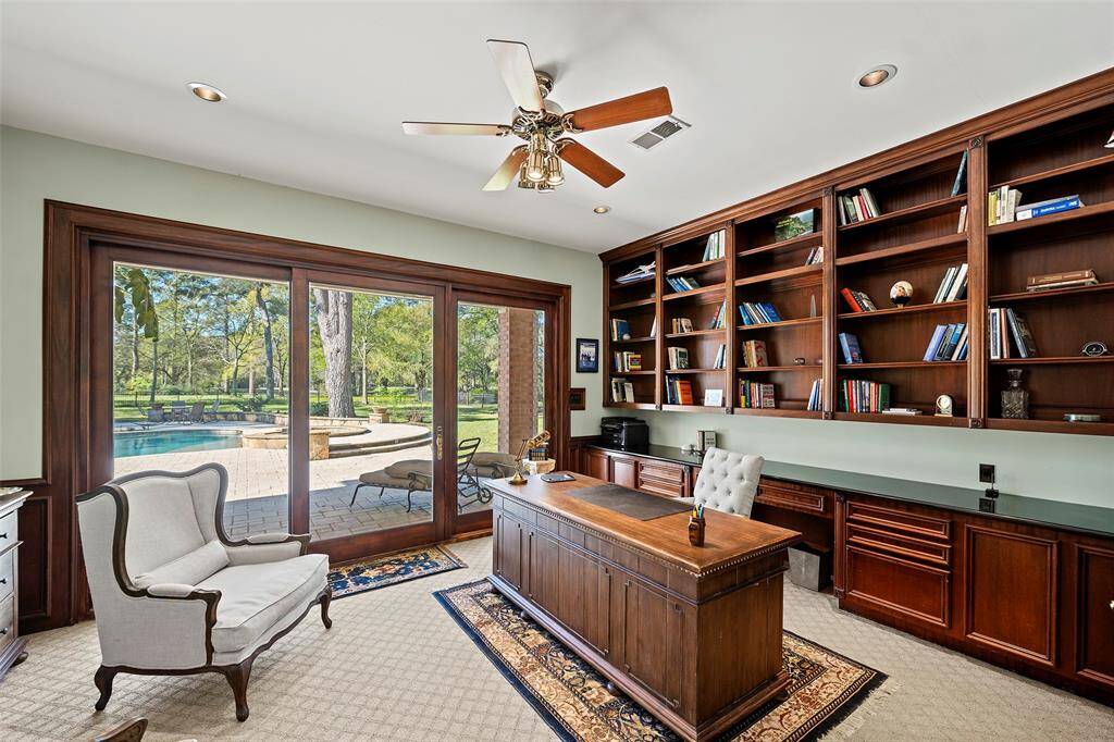 Just off the entry, you will find the private office tucked behind double glass doors! Thoughtful features include a custom built-in credenza the length of the wall, providing ample storage space, custom built-in bookcase shelving, recessed lighting and a gorgeous half wall paneling that makes a statement!