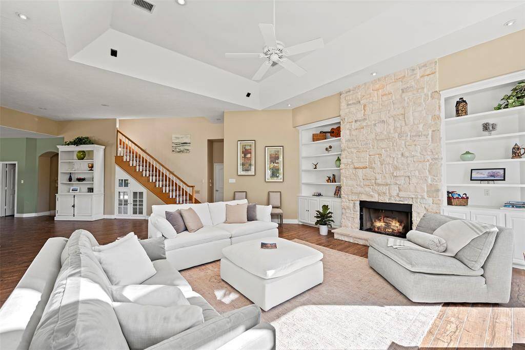 A marvelous stone fireplace with hearth is flanked by custom built-ins for pretty displays and will surely warm the hearts of all that gather here! This space is so cozy and inviting, you'll want to kick up your feet and stay awhile!