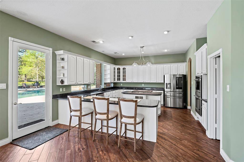 The chef of the home has plenty of storage space in this island kitchen! Freshly painted, crisp white cabinets adorned with granite countertops offers plenty of prep and storage space! And look at the windows perched above the sink and below the cabinet, creating an inviting place to do the task of dishes or watch the kids at play in the backyard oasis!