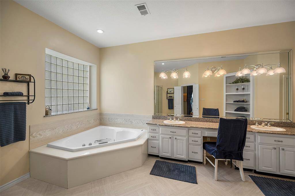 This spa-like bath will definitely be a place of respite for you after a long day of work or play! Take a soak in the jacuzzi tub, or sit at the vanity and do your nightly routine in style! This bathroom offers dual vanity sinks, granite countertops, drawers and cabinets for storage and a custom shelving unit for display or even more storage!