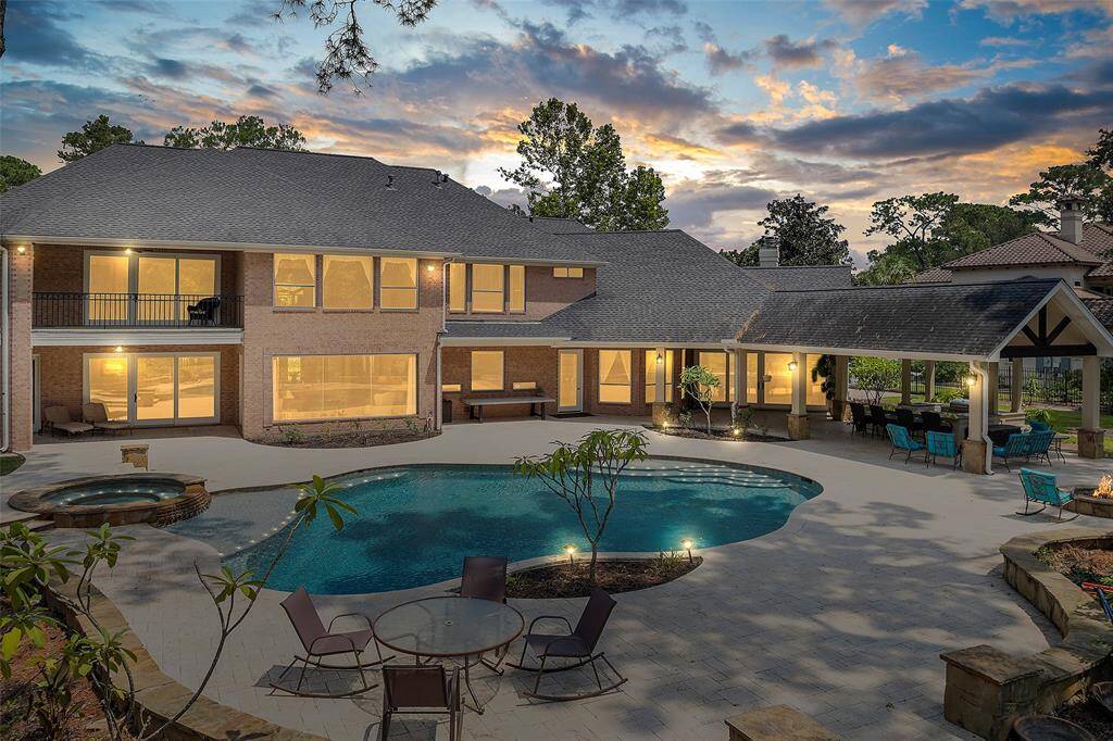 This home exudes warmth and happiness as the day turns to dusk! This view shows the two covered patio areas, the upstairs balcony, and the 4 sides of brick this home offers, making it easier to maintain!