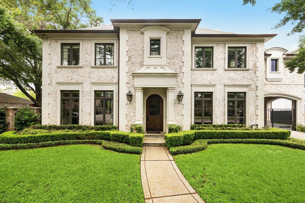 Timeless elegance meets modern refinement in this beautifully crafted brick estate, nestled behind manicured hedges and mature trees in a prime location. The stately façade features classic architectural detailing, arched entryway, and expansive windows that flood the interiors with natural light.