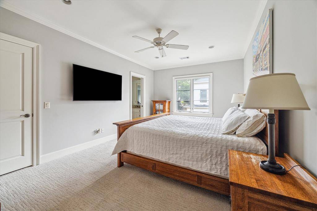 Another comfortable bedroom on the second floor is filled with natural light from a large window, offering a cozy and inviting space. This bedroom shares a full bathroom that conveniently leads into the game room, making it a perfect setup for family members or guests to enjoy both privacy and easy access to shared spaces.