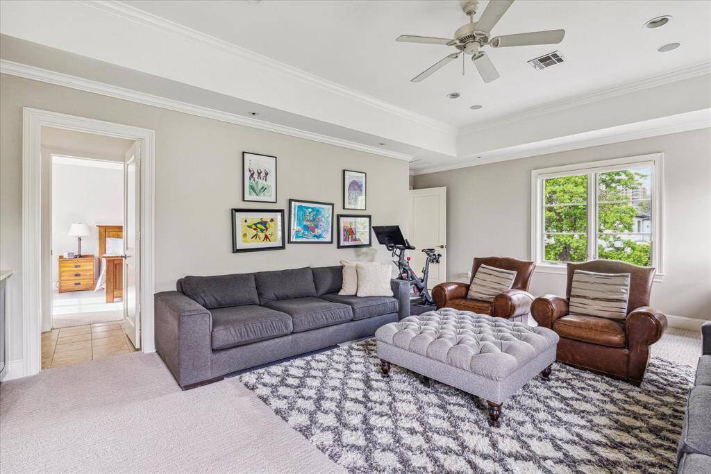 A versatile upstairs game room with large windows and tray ceiling offers direct access to a full Jack-and-Jill bath shared with an adjacent secondary bedroom.