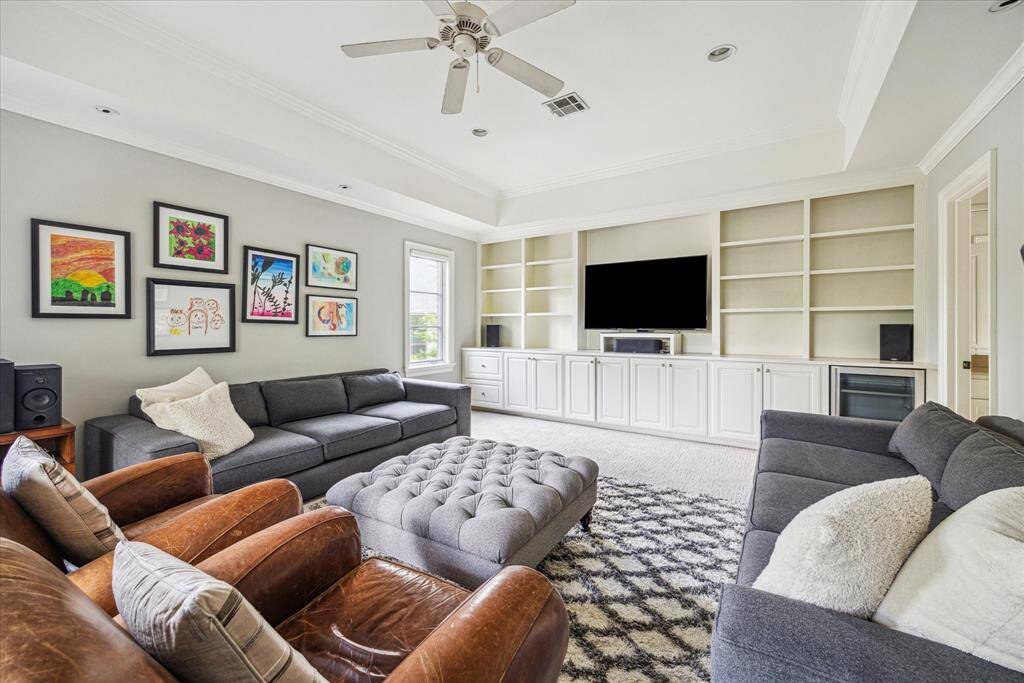 The spacious game room, located at the end of the upstairs hall, offers plenty of room for entertainment and relaxation. Built-in bookshelves line the walls, providing a place for books, games, and décor. With ample cabinet storage, the room is perfectly equipped to keep everything organized and tidy, making it an ideal spot for family fun and activities.