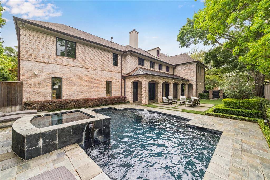 The inviting pool features elegant fountains that add a soothing ambiance and a touch of luxury. A connected hot tub offers the perfect spot to unwind, whether enjoying a quiet evening or entertaining guests. Together, they create a resort-style atmosphere right at home.