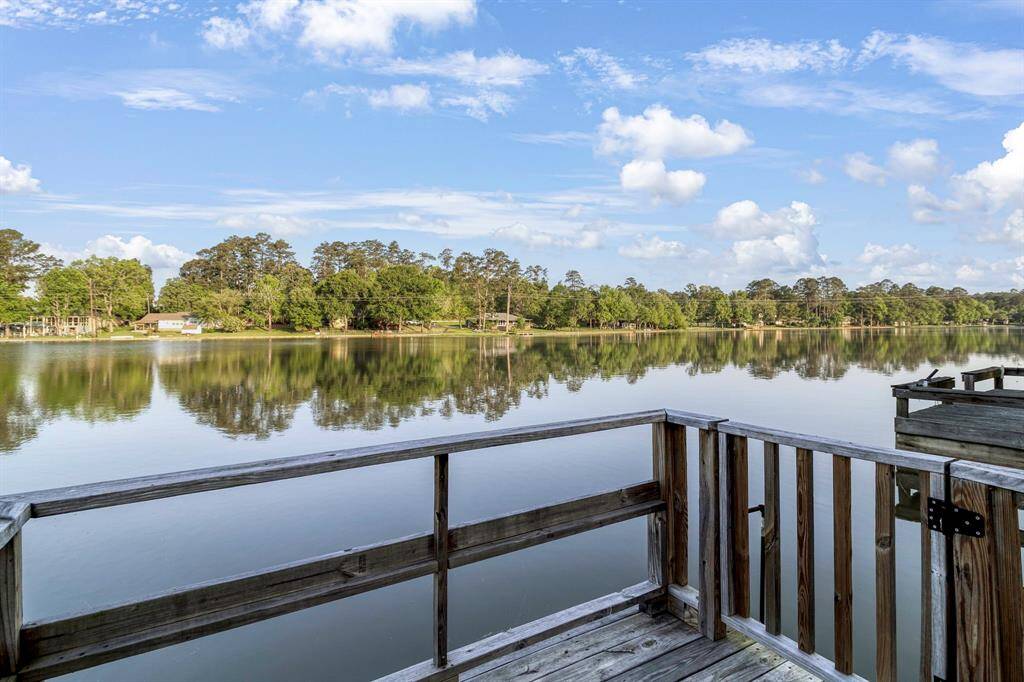 Experience tranquility with breathtaking lake views from your private wooden deck, surrounded by lush greenery and clear skies. Perfect for relaxation. **403 E Lake Drive, Livingston, TX 77351**
