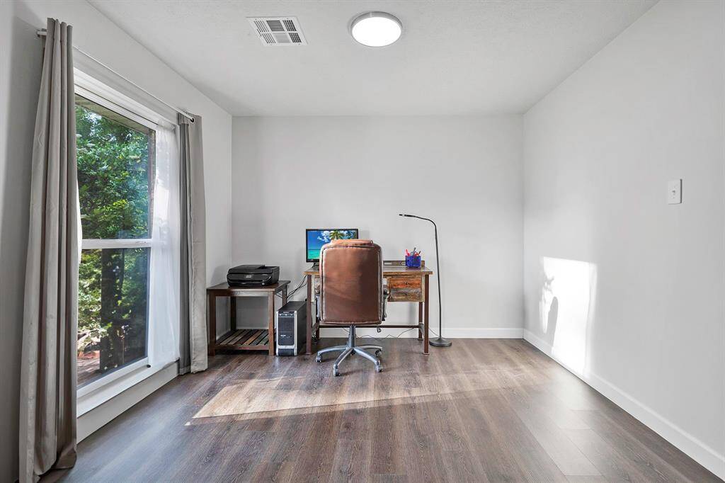Your office area/Flex space has a large window, natural light, and views of mature landscaping **403 E Lake Drive, Livingston, TX 77351**