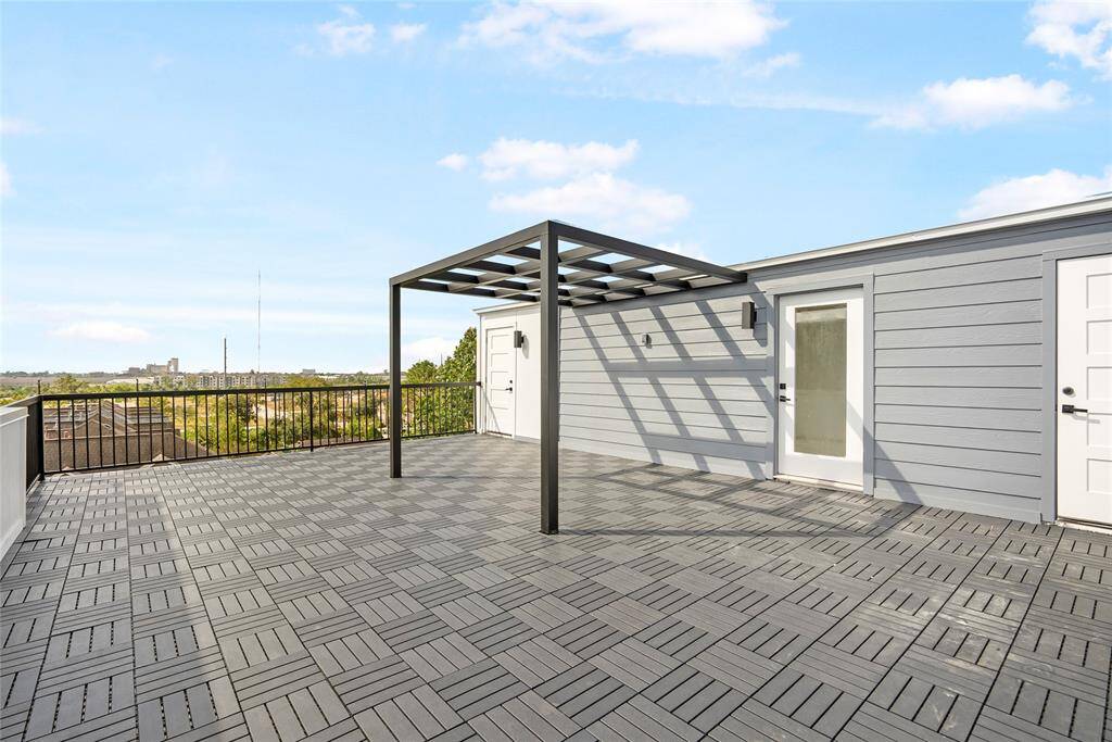 This is a spacious rooftop terrace with modern decking, a pergola, and scenic views of the East River Development, perfect for outdoor relaxation and entertaining.