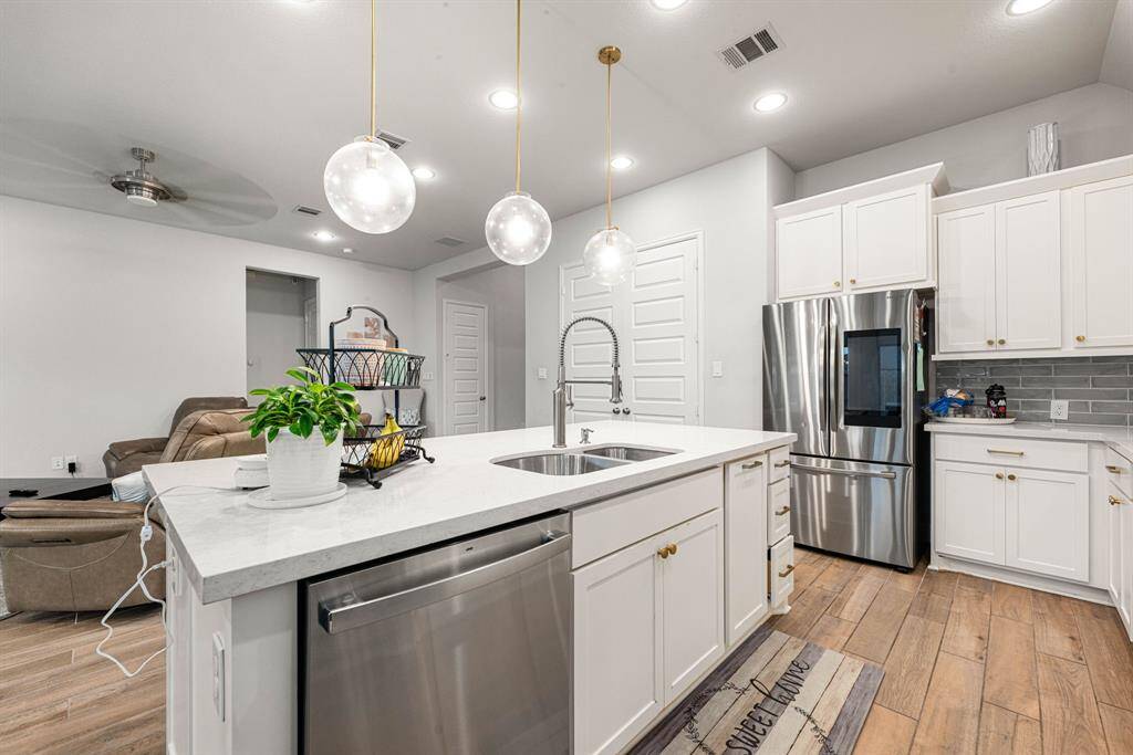 This kitchen is by far any chef’s dream! This spacious kitchen features large windows, white cabinets, quartz countertops, SS appliances, custom modern tile backsplash, recessed lighting with additional custom pendant lighting, quartz kitchen island with double sink and space for breakfast bar and a walk-in pantry all overlooking your huge family room.