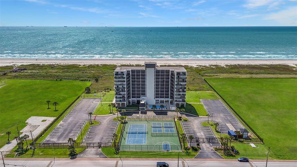 Soak in the incredible location from above—this condo sits beachfront with uninterrupted Gulf views, lush green space, and direct access to the sand and surf.