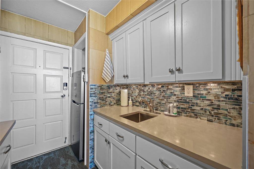 Enjoy a fully updated kitchen with sleek quartz countertops, soft-close cabinetry, and an eye-catching mosaic tile backsplash. The layout maximizes storage and prep space while maintaining a light and airy feel.