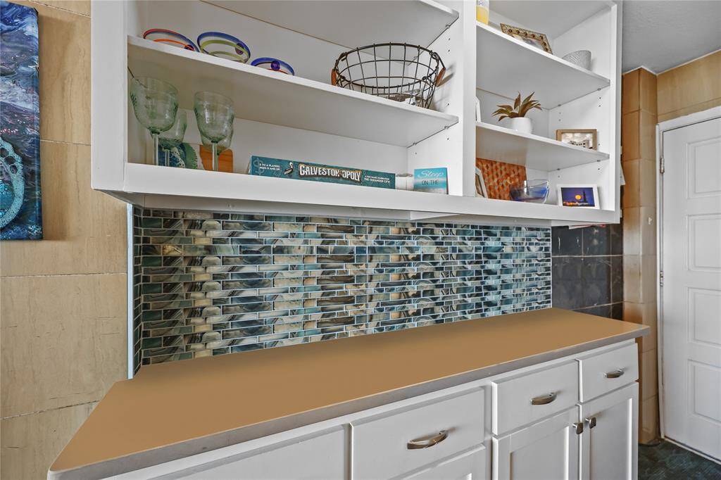The built-in buffet-style cabinetry features open shelving for display and additional storage below—perfect for barware, dishware, or décor to complement the coastal vibe.