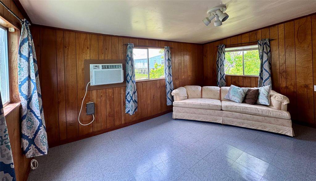 The living area boasts warm wooden walls that add character and charm, along with a cozy breakfast bar that opens to the kitchen—perfect for casual dining and easy conversation while cooking.